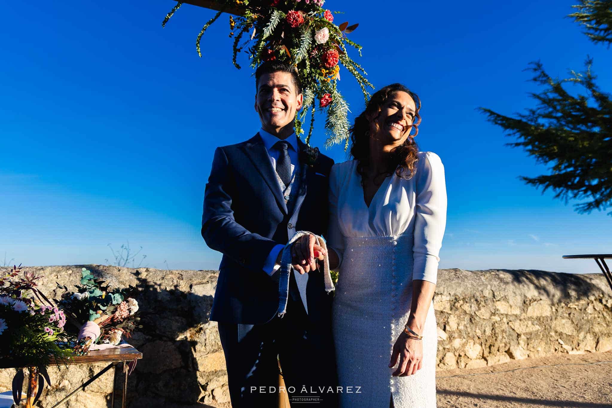 Novios riéndose en su boda en Madrid. Con ceremonia en exterior y el paisaje de Madrid de fondo